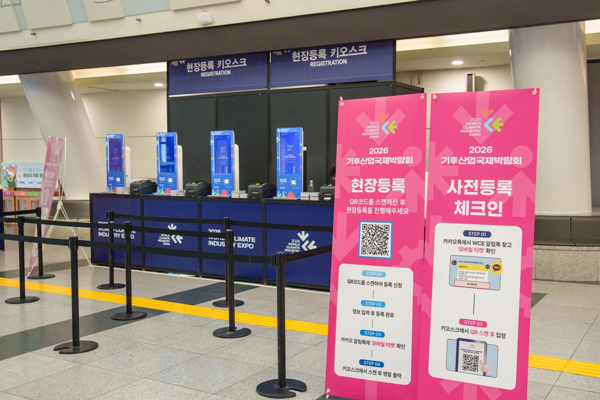 WCE Expo 현장의 현장등록 키오스크와 사전등록 체크인 안내판. 서로 다른 업무의 순서를 나눠 표시한 모습